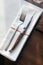 Knife and fork with napkin on wooden table for fine dining. Luxury cutlery set