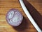 Knife and fresh onion slice on wooden cutting board surface. Muted colors effect