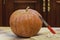 Knife rests on round pumpkin on table