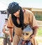 A knight festival participant helps a small visitor to dress armor in Goren park in Israel