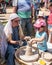 A knight festival participant tells a small visitor how to make a clay pitcher on a potter`s wheel in Goren park in Israel