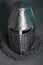 Knight`s helmet and chainmail hood. Gray background.