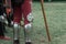 Knight stands on the grass, legs of a knight in armor close up