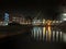 Knights Way Footbridge crossing the river aire at the lock entrance to clarence dock in leeds at night with buildings and lights