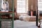 Knit blanket and cushions on bed in japanese bedroom interior with window and bonsai