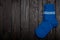 Knit blue wool socks on dark wooden background.