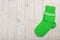 Knit green wool socks on wooden background light.