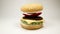 Knitted burger bun falls on burger on a white background, Close Up