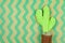 Knitted cactus on green wavy pattern brown paper, Home decoration.