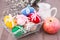 Knitted Easter eggs tied with colored ribbons in a metal basket, an apple, a jug and willow