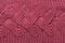 Knitted fabric of burgundy color, large knit, with large patterns arranged horizontally, macro photography