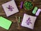 Knitted handmade watches, square pillow, needles and lilac, green, white yarn balls on wooden table. Translation of the hierogly