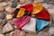knitted hats of different colors lie on stone surface, large cobblestones