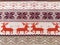 Knitted patterns with snowflakes, deer, flowers, broken stripes. Orange, red brown, white, beige woolen threads. Folk art. Warm