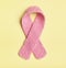 Knitted Pink Womens Breast Cancer Symbol in center on yellow background with room or space on sides for copy, text, or your words.