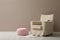 Knitted pouf, fuzzy rug with slippers and armchair near beige wall indoors. Space for text