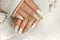 Knitted sand manicure on long oval nails with golden sequins and threads