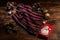 Knitted scarf with black, white and red stripes, Christmas decorations and a metal box with a picture of Santa Claus on a wooden