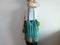 Knitted string bag with products oranges and greens. the shopper is blue. crochet eco bag in the hand of a girl in a