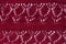 Knitted texture burgundy fabric background. Dark red cloth on light surface for design. Handmade backdrop material