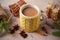 Knitted yellow cup with hot winter drink, cookies, cinnamon, decorations. Cozy.