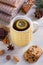 Knitted yellow cup with tea drink, cookies, cinnamon, winter decorations.