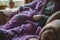 knitter resting with a halffinished purple woolen shawl on their lap