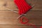 Knitting needles and thread in heart shape on wood