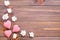 Knitting pink hearts and white flowers on a wooden background