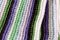 Knitting striped rug with white, purple, green stripes