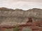 A Knobby Red Rock Formation with Gray Cliffs Behind