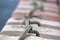 Knot on boat bollard detail on blue water background