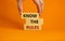 Know the rules symbol. Wooden blocks with words `know the rules`. Male hand. Beautiful orange background. Copy space. Business a