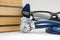 Knowledge, education, medicine and medical practice. Stack of books lies near stethoscope, neurological rubber hammer and points o
