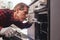 He knows how to solve this problem. Close-up of repairman examining oven