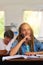 She knows the importance of good grades. a young schoolgirl smiling while sitting at her desk in class.