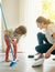 She knows to clean up her mess. a mother and daughter sweeping the floor together.