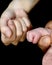 The knuckles of a newborn baby`s hands bump against the knuckles of its mother.