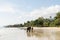 Koh Chang, Thailand - June 2019: Thai man walking an elephant on sandy Long Beach