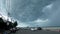 KOH SAMUI ISLAND, THAILAND - 14 JULY 2019 Gloomy landscape of seafront with cars and people awaiting hurricane. Motorbikes riding