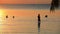 Koh tao thailand - march6,2018 : unidentified tourist standing in shallow water of koh tao beach against beautiful sunset sky