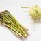 Kohlrabi, also known as german turnip, and a bunch of asparagus. White background, directly above