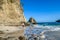 Koka Beach - A man walking on an idyllic beach, surrounded by hills