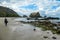 Koka Beach - A woman walking on an idyllic beach, surrounded by hills