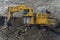 Komatsu PC2000 excavator rides through a dusty quarry.