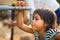 Kon Tum, Vietnam - Mar 29, 2016: A little girl drink water from outdoor tap which water supplied by drilling well in Central Highl