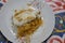 Konafa topped with whipped cream, raisins, walnuts, shredded coconut and stuffed with cream and fresh mango layer and soaked with