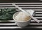 Konjac or Shirataki noodles in white bowl  with metal chopsticks, black and white stripe table cloth background