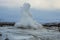 Konungshver geyser steams- Strokkur geyser erupts in the background, in Iceland