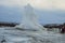 Konungshver geyser steams- Strokkur geyser erupts in the background, in Iceland